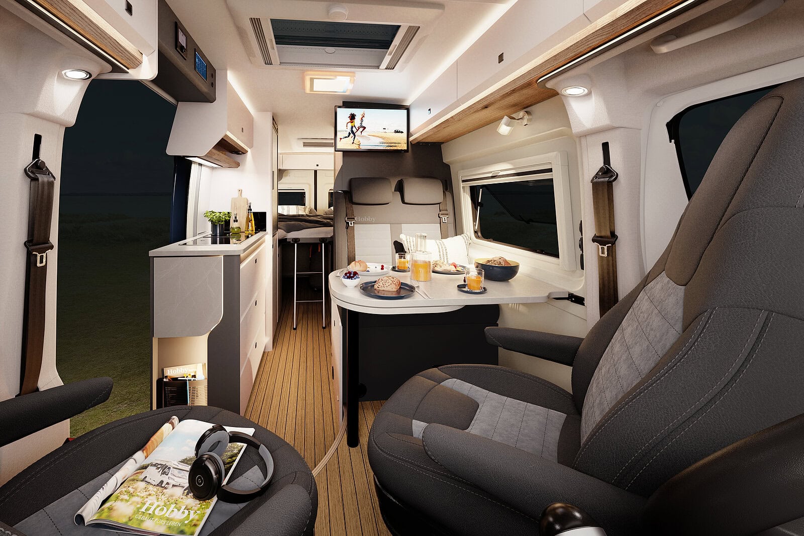 Invändig bild i en campervan i kvällsljus med kvällsmat på bordet